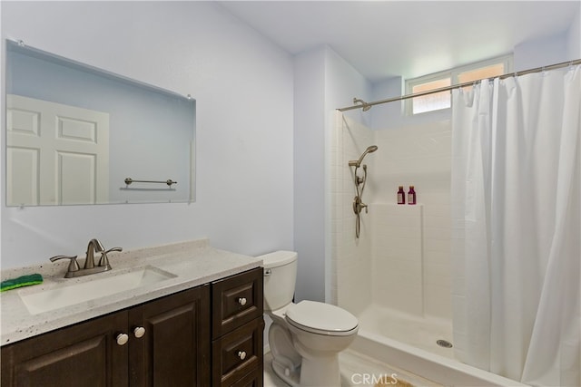 full bathroom featuring toilet, vanity, and tiled shower