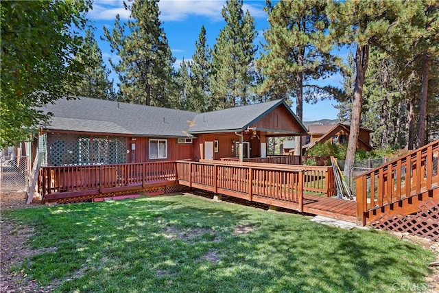 rear view of property featuring a yard and a deck