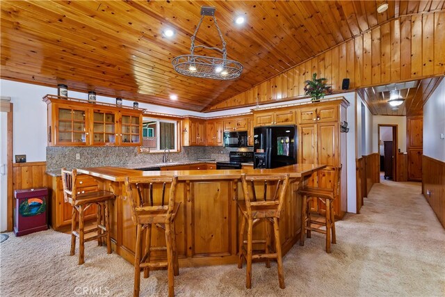 kitchen featuring light carpet, kitchen peninsula, black appliances, wooden walls, and wood ceiling