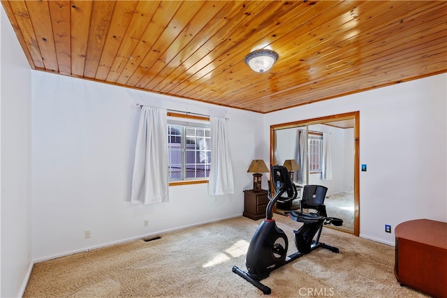 exercise room featuring wood ceiling and light carpet