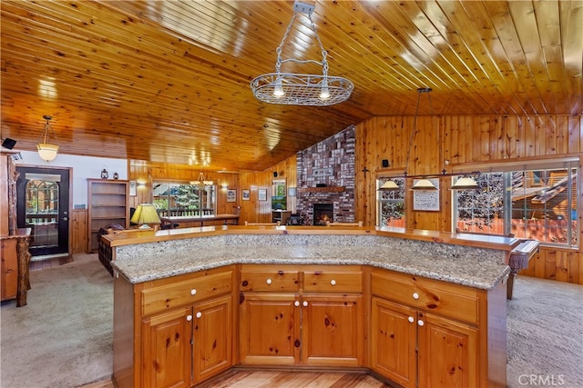 kitchen featuring light stone countertops, wooden walls, wood ceiling, and open floor plan