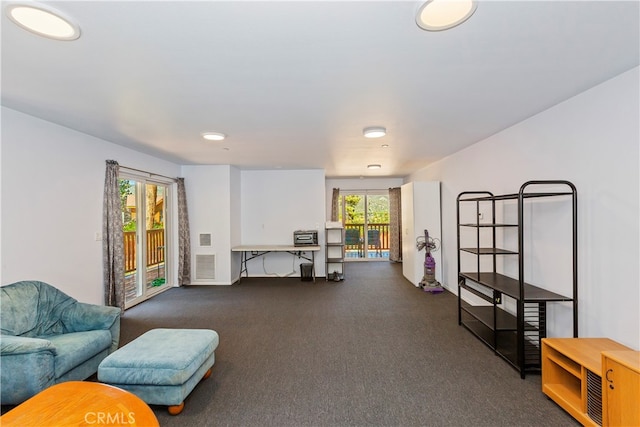living room featuring dark carpet and visible vents