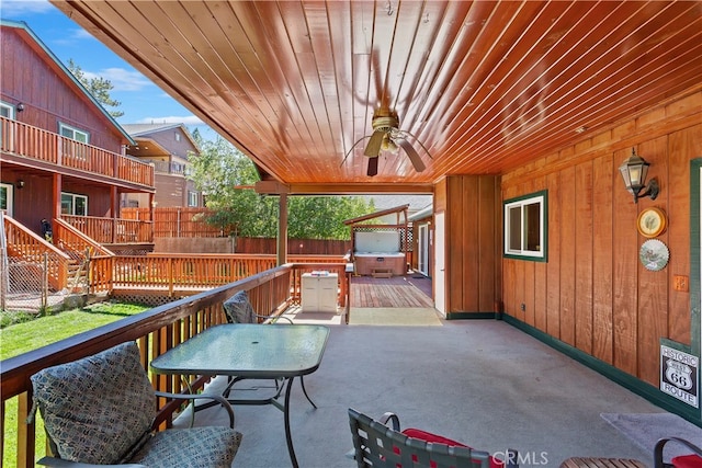 view of patio featuring a deck, ceiling fan, and a jacuzzi