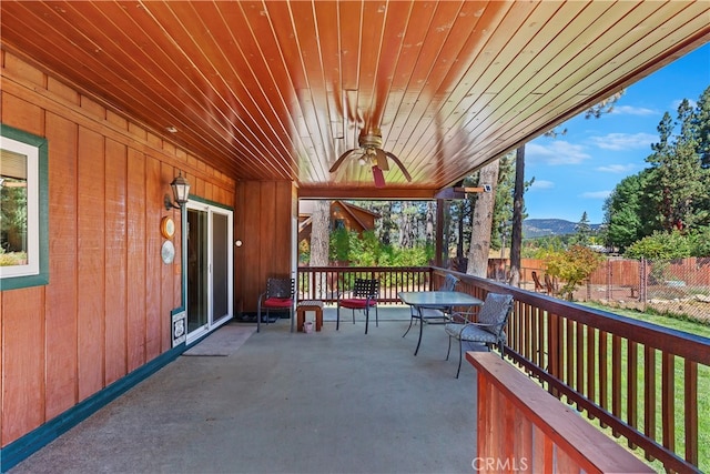 view of patio with a ceiling fan, a mountain view, and fence