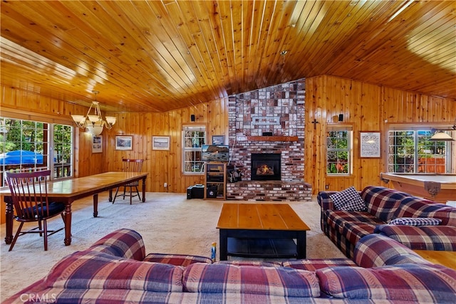 carpeted living room featuring a notable chandelier, a fireplace, vaulted ceiling, and wooden ceiling