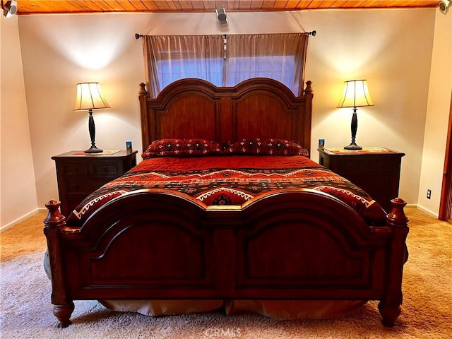 bedroom with baseboards, carpet flooring, and wood ceiling