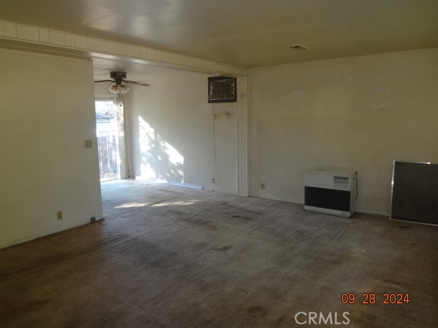 interior space with a wall unit AC, ceiling fan, and carpet floors