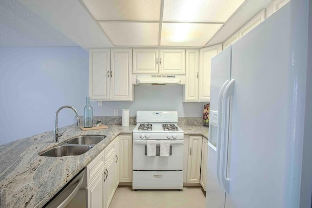 kitchen featuring light stone countertops, white cabinetry, white appliances, and sink