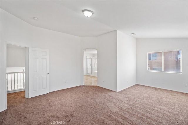 carpeted spare room with lofted ceiling