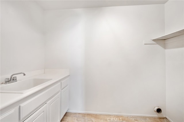 laundry room with cabinets and sink