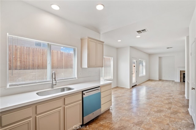 kitchen with a tile fireplace, sink, and stainless steel dishwasher