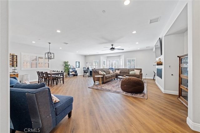 living room with ceiling fan and light hardwood / wood-style flooring