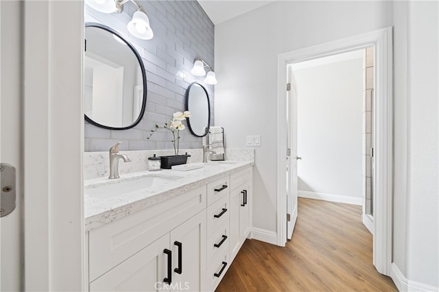 bathroom with vanity, hardwood / wood-style floors, and tasteful backsplash