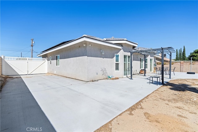 rear view of property with a pergola and a patio