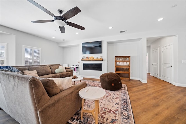 living room featuring ceiling fan and hardwood / wood-style flooring