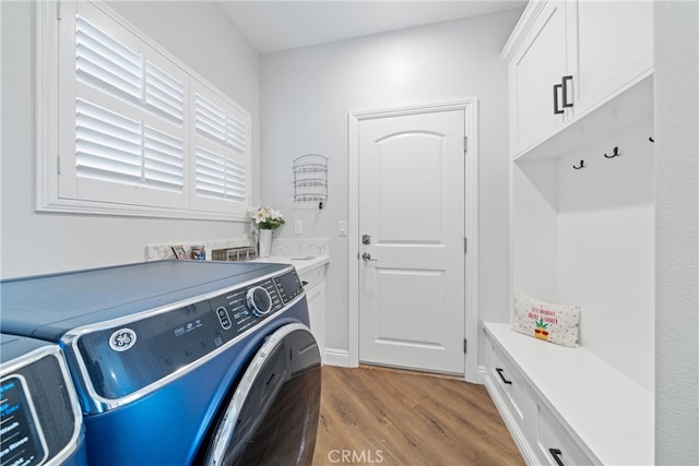 washroom with light hardwood / wood-style flooring, independent washer and dryer, and cabinets