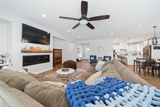 living room with ceiling fan and dark wood-type flooring