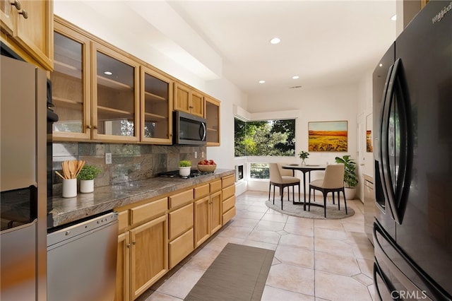 kitchen with light tile patterned floors, decorative backsplash, and appliances with stainless steel finishes