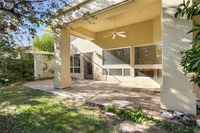 back of house with ceiling fan and a patio area