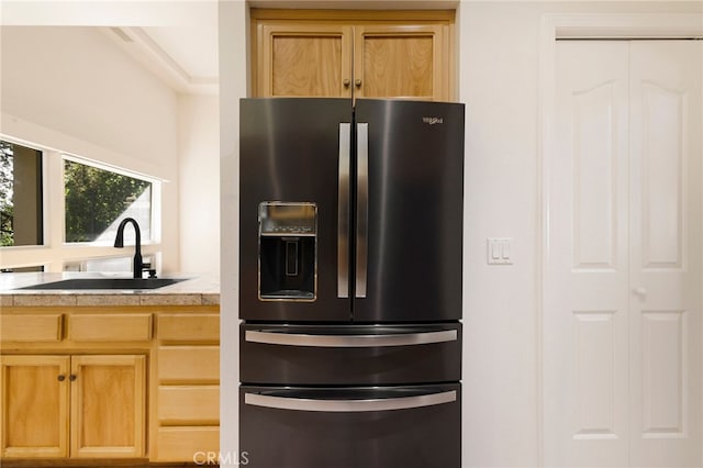 kitchen featuring black fridge, sink, and light brown cabinets