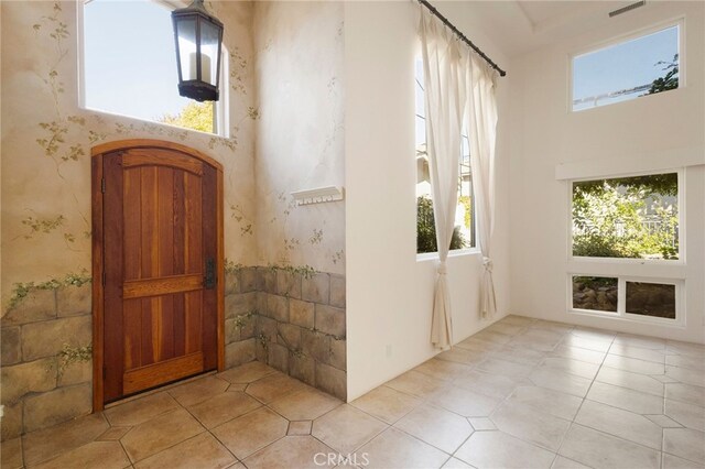 entrance foyer with a towering ceiling and a healthy amount of sunlight