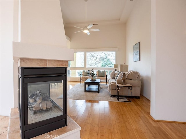 3185 Via Casita Pl, Chico, CA 95928 - living room featuring a towering ceiling, ceiling fan, light wood finished floors, and a multi sided fireplace