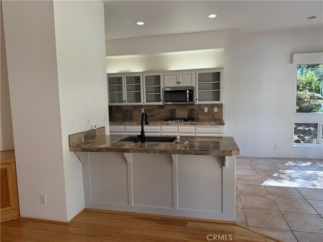 3185 Via Casita Pl, Chico, CA 95928 - kitchen featuring stainless steel appliances, decorative backsplash, a peninsula, glass insert cabinets, and a kitchen bar