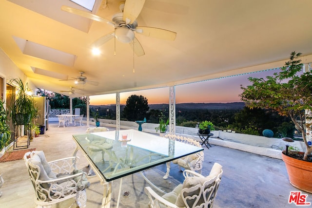 patio terrace at dusk featuring ceiling fan