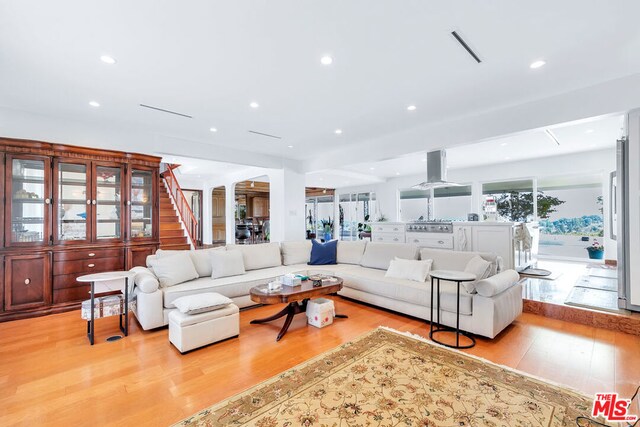 living room featuring light wood-type flooring and ornate columns