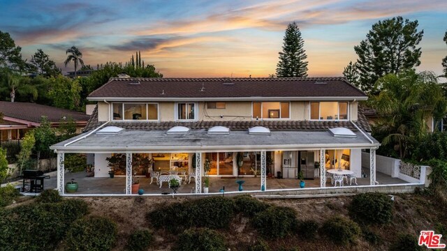 back house at dusk with a patio