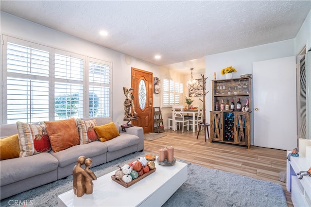 living room with a textured ceiling and light wood-type flooring