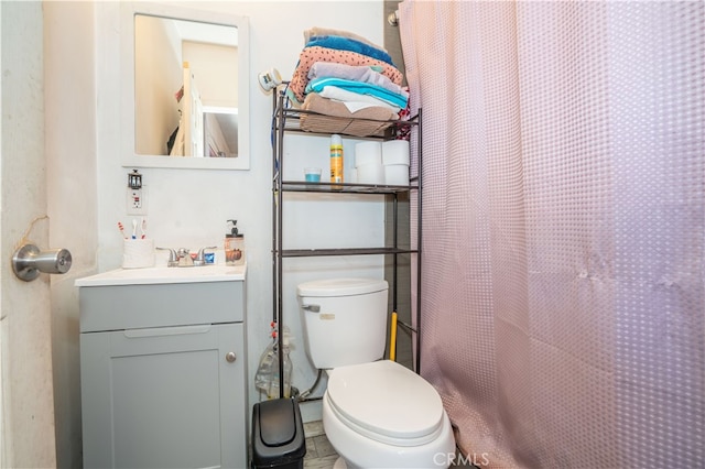 bathroom with walk in shower, vanity, and toilet