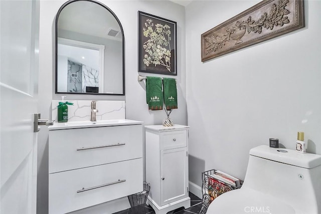 bathroom featuring vanity, backsplash, and toilet