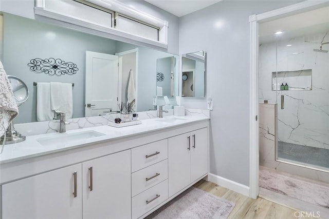 bathroom with vanity, a shower with door, and wood-type flooring