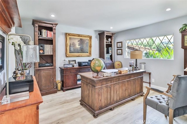 home office with light hardwood / wood-style flooring