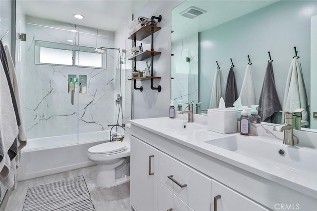 full bathroom featuring vanity, tiled shower / bath combo, and toilet