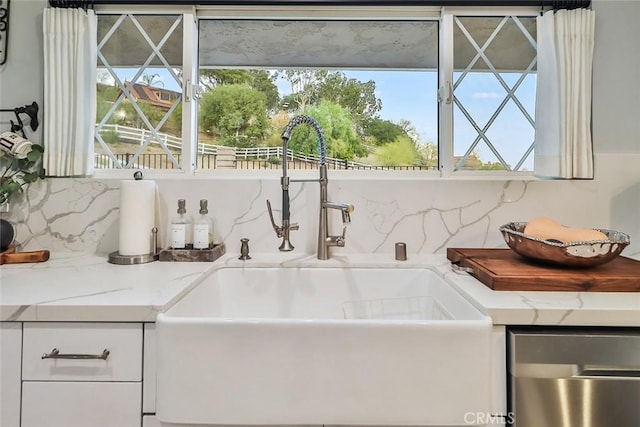 interior details with light stone counters, sink, and backsplash