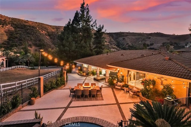 patio terrace at dusk featuring a mountain view