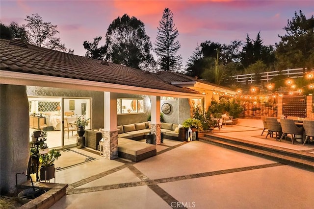 patio terrace at dusk featuring an outdoor hangout area