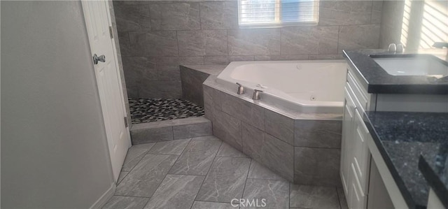 bathroom with vanity and a relaxing tiled tub