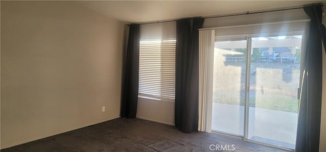 unfurnished room with dark colored carpet