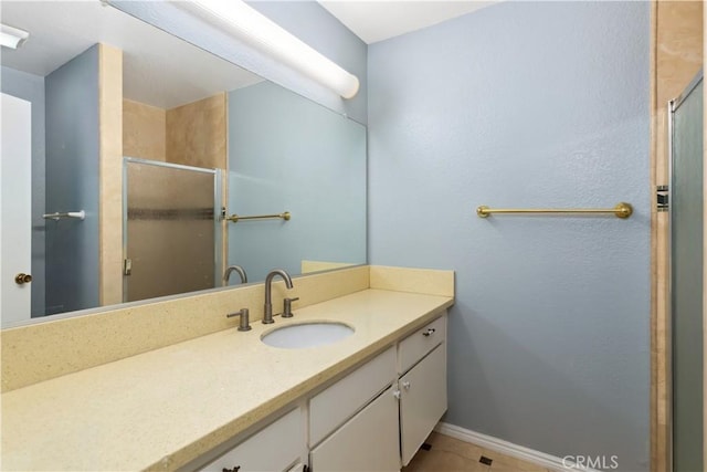 bathroom featuring tile patterned floors, vanity, and a shower with door