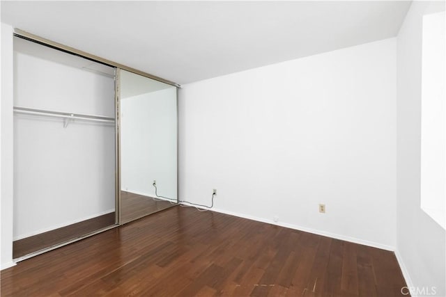 unfurnished bedroom featuring hardwood / wood-style floors and a closet