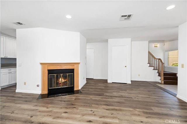 unfurnished living room with dark wood-type flooring