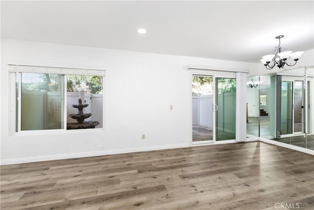 empty room featuring dark wood-type flooring and a chandelier