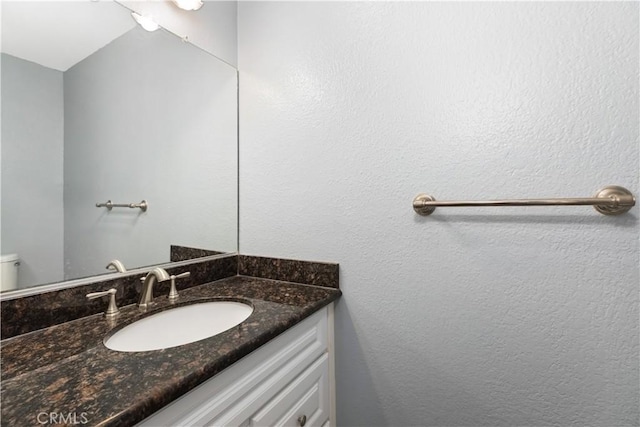 bathroom featuring toilet, vanity, and vaulted ceiling