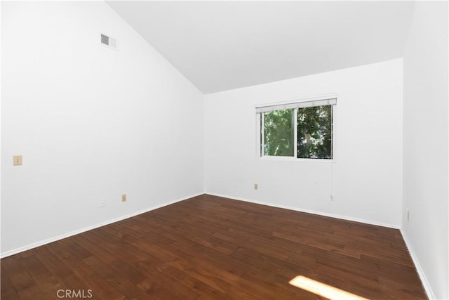 empty room featuring high vaulted ceiling and dark wood-type flooring