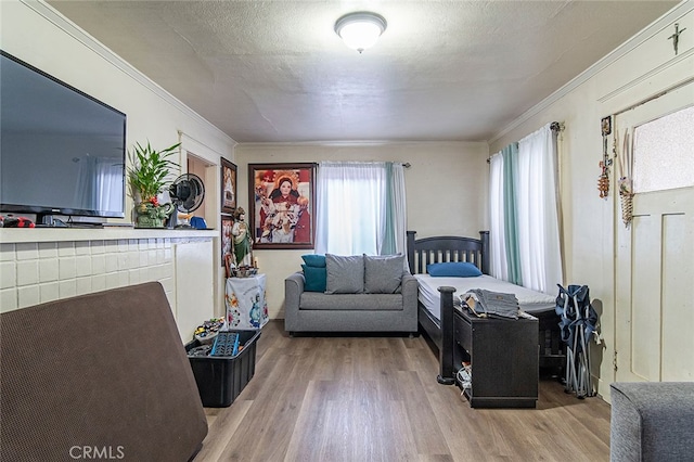 bedroom with hardwood / wood-style flooring, crown molding, and a textured ceiling