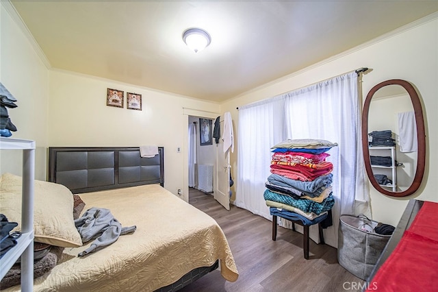 bedroom with ornamental molding and hardwood / wood-style floors