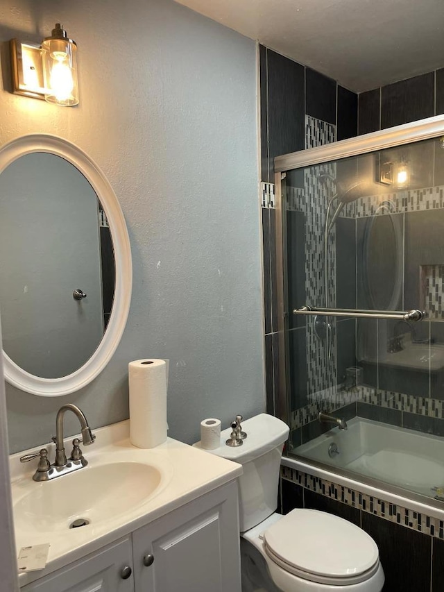 full bathroom featuring shower / bath combination with glass door, vanity, and toilet